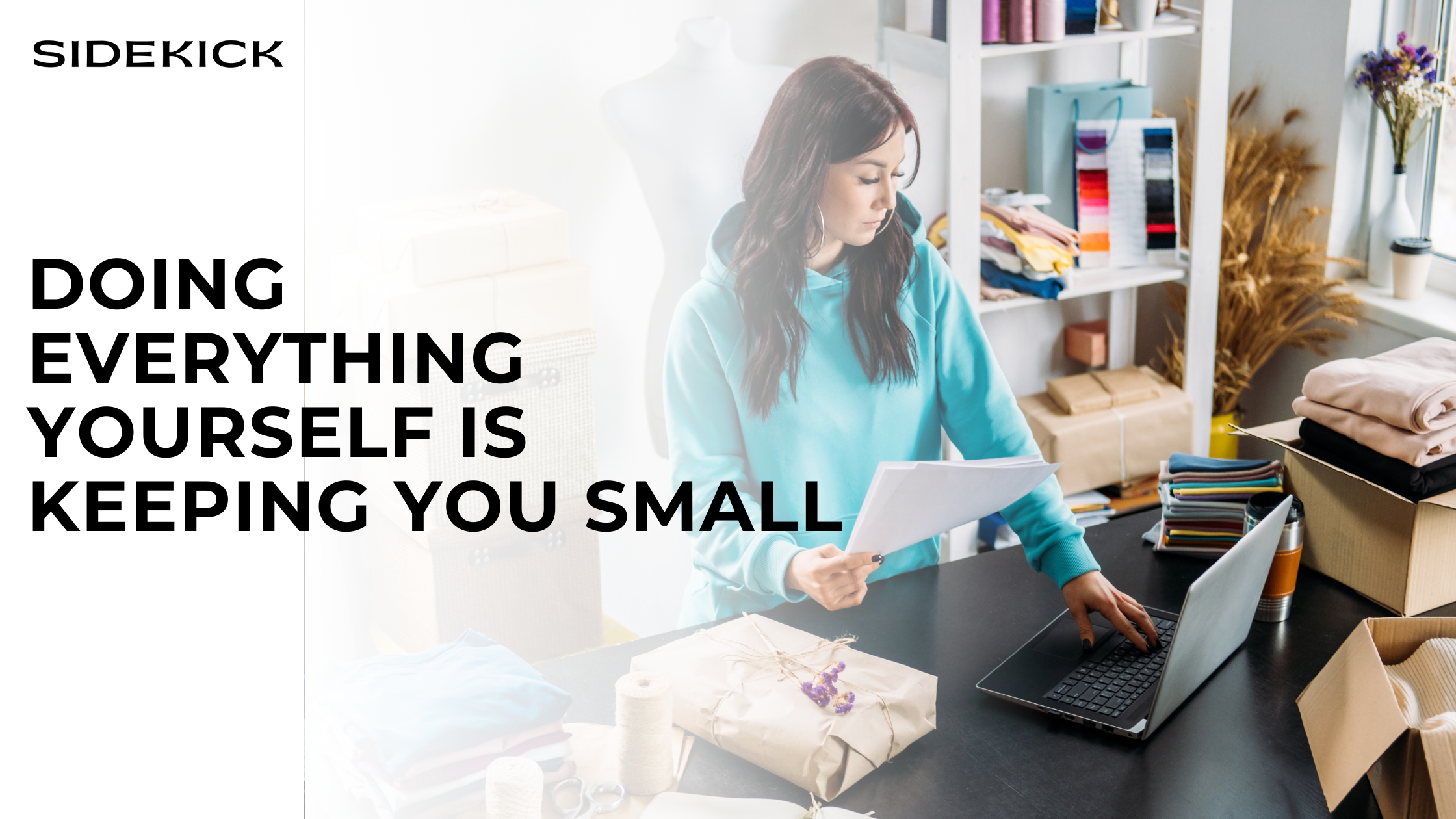 Woman in a hoodie working on a laptop in a small business workspace with text: “Doing everything yourself is keeping you small